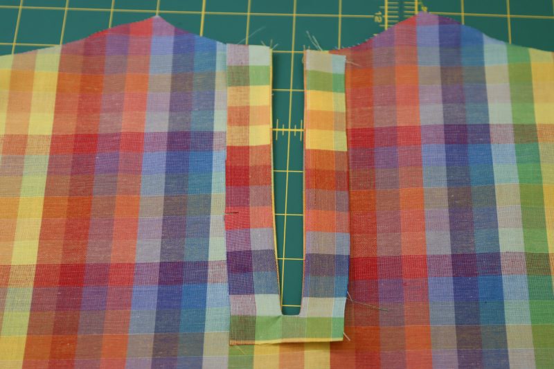 How To Flip Keyhole Facing To Wrong Side - Rainbow Checks Cotton Shirting - Mood Fabrics - Bayport Blouse Free Sewing Pattern Tutorial - MDF494 - Mood Fabrics Sewciety Blog - Flip the keyhole facing to the wrong side of the blouse and press.