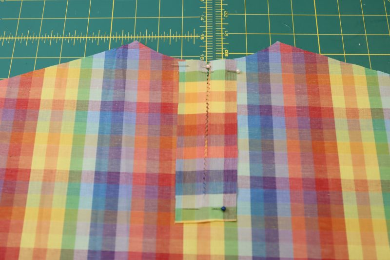 How To Pin Keyhole Facing To Top Back - Rainbow Checks Cotton Shirting - Mood Fabrics - Bayport Blouse Free Sewing Pattern Tutorial - MDF494 - Mood Fabrics Sewciety Blog - Pin the keyhole facing to the right side of the back of the blouse.