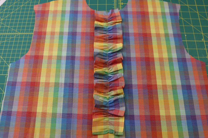 How To Pin Sew Center Ruffle To Top Front - Rainbow Checks Cotton Shirting - Mood Fabrics - Bayport Blouse Free Sewing Pattern Tutorial - MDF494 - Mood Fabrics Sewciety Blog - Pin and sew the ruffle to the center front of the blouse.