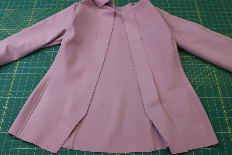 How To Place Placket Facings On Cardigan Front - Stretch Ponte Knit - Mood Fabrics - Camarillo Cardigan and Magdalene Midi Skirt Free Sewing Pattern Tutorial - MDF490 - Mood Fabrics Sewciety Blog - Place the button placket facings right sides together with the center front opening of the cardigan.