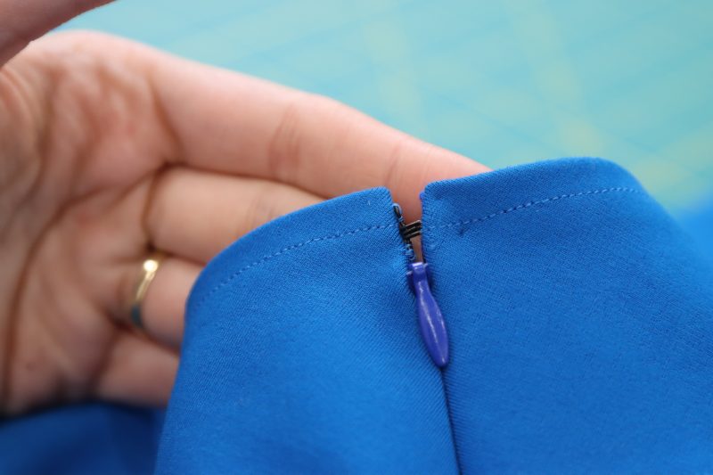 How To Sew Hook And Eye By Hand - Hooks And Eyes - Mood Fabrics - Topeka Keyhole Dress Free Sewing Pattern Tutorial - MDF496 - Mood Fabrics Sewciety Blog - Hand sew a hook and eye closure above the zipper.