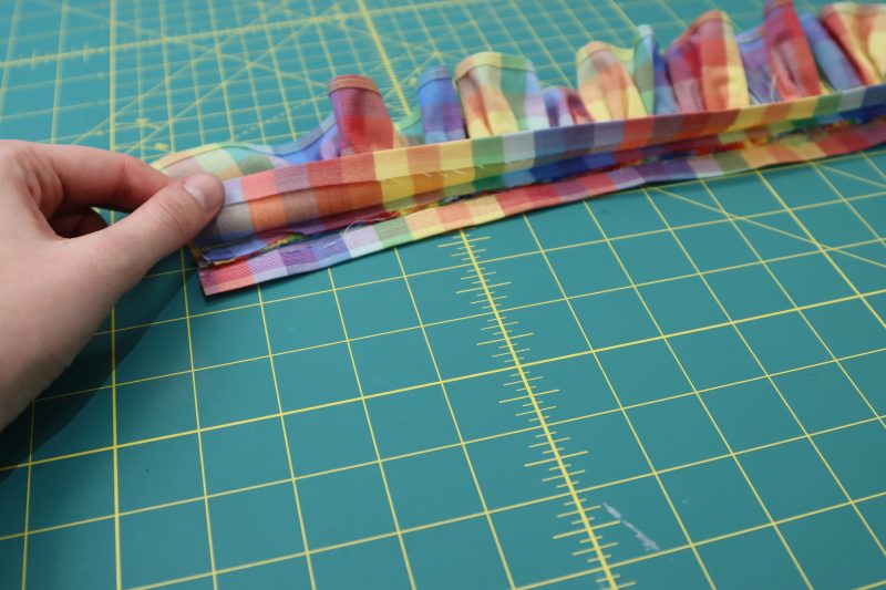 How To Press Collar Raw Edges - Rainbow Checks Cotton Shirting - Mood Fabrics - Bayport Blouse Free Sewing Pattern Tutorial - MDF494 - Mood Fabrics Sewciety Blog - Press a ½ inch fold into the raw edges of the collar.