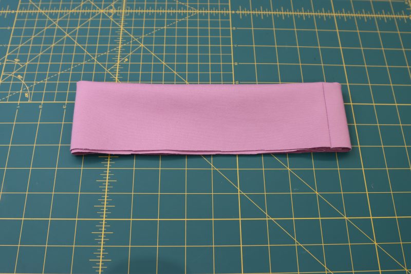 How To Fold Wasitband - Stretch Ponte Knit - Mood Fabrics - Camarillo Cardigan and Magdalene Midi Skirt Free Sewing Pattern Tutorial - MDF490 - Mood Fabrics Sewciety Blog - Fold the closed waistband wrong sides together to make it two layers thick and hide the seam allowance.