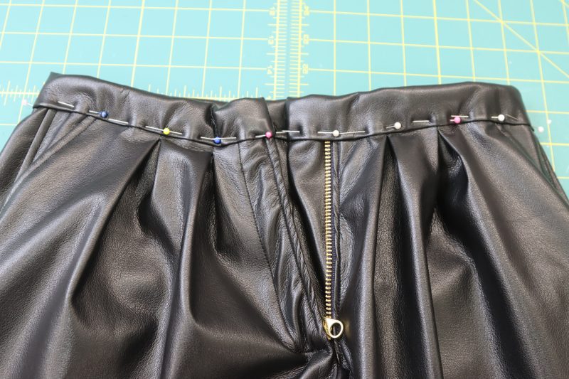 How To Pin Waistband To Waistline - Buttery Faux Leather - Mood Fabrics - Dresden Shorts Free Sewing Pattern Tutorial - MDF493 - Mood Fabrics Sewciety Blog - Pin the folded waistband to the waistline.