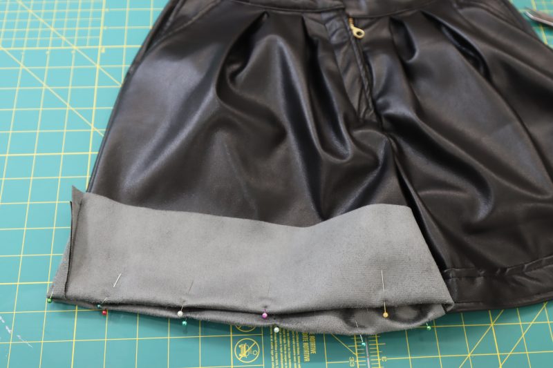 How To Fold Shorts Hem - Buttery Faux Leather - Mood Fabrics - Dresden Shorts Free Sewing Pattern Tutorial - MDF493 - Mood Fabrics Sewciety Blog - Fold and pin the bottom of the shorts hem.