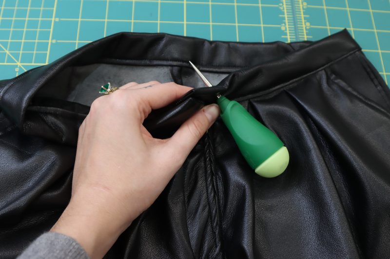 How To Cut Hole For Button Backing - Buttery Faux Leather - Mood Fabrics - Dresden Shorts Free Sewing Pattern Tutorial - MDF493 - Mood Fabrics Sewciety Blog - Poke a hole through the waistband with an awl.