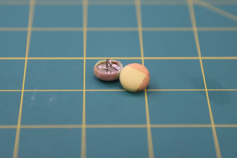 How To Insert Fabric Into Button Cover Kit - Maxant Button Cover Kit - Mood Fabrics - Bayport Blouse Free Sewing Pattern Tutorial - MDF494 - Mood Fabrics Sewciety Blog - Make two fabric covered buttons.