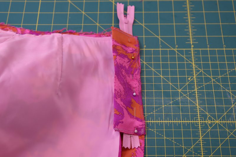 How To Pin Zipper To Opposite Front Pants - Regular Zipper - Mood Fabrics - Chelsea Brocade Set Free Sewing Pattern Tutorial - MDF508 - Mood Fabrics Sewciety Blog - Pin the other side of the zipper between the fly shield and the other side of the center front of the pants.