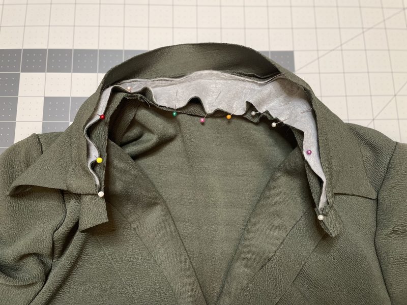 How To Pin Sew Collar Stand To Neckline - Stretch Liverpool Knit - Mood Fabrics - Cove Collared Wrap Top Free Sewing Pattern Tutorial - MDF498 - Mood Fabrics Sewciety Blog - Pin and sew the interfaced side of the collar stand to the neckline.