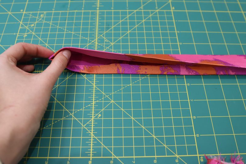 How To Fold Waistband Raw Edges - Luxury Polyester Brocade - Mood Fabrics - Chelsea Brocade Set Free Sewing Pattern Tutorial - MDF508 - Mood Fabrics Sewciety Blog - Fold the raw edges of the waistband into the inside of the waistband.