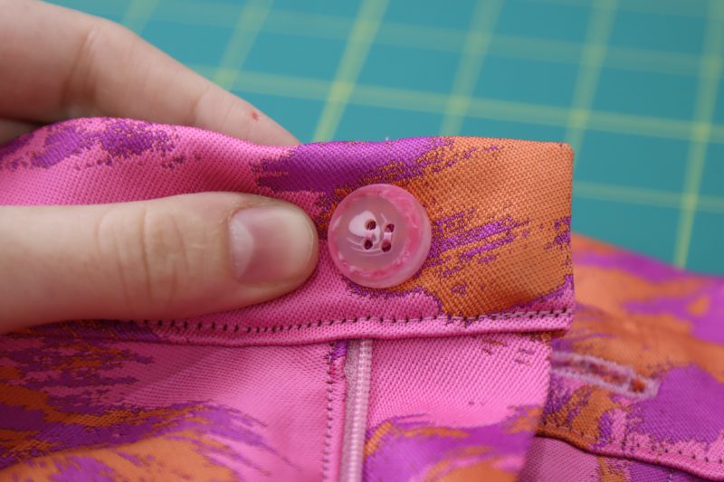 How To Sew Button By Hand - Hot Pink Swirl Button - Mood Fabrics - Chelsea Brocade Set Free Sewing Pattern Tutorial - MDF508 - Mood Fabrics Sewciety Blog - Hand sew a button directly behind the buttonhole.