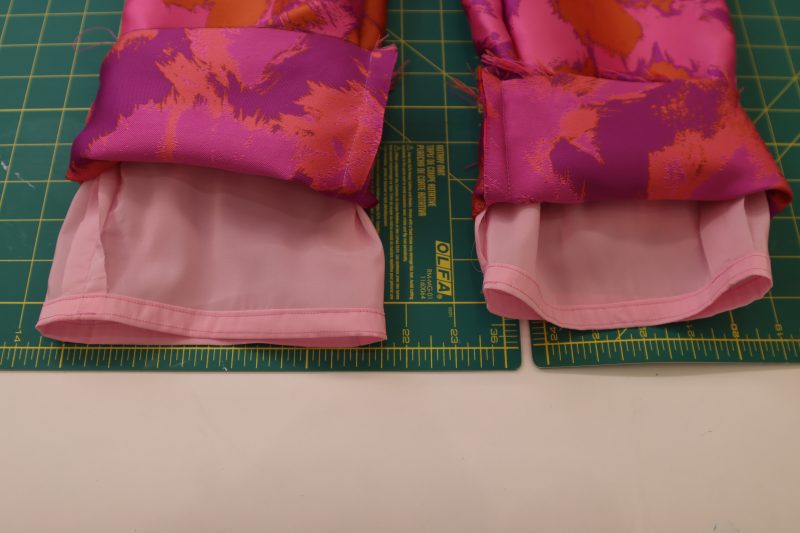 How To Sew Rolled Hem On Lining - Stretch Polyester Twill Lining - Mood Fabrics - Chelsea Brocade Set Free Sewing Pattern Tutorial - MDF508 - Mood Fabrics Sewciety Blog - Sew a rolled hem on the bottom of the lining pants.