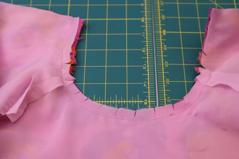How To Clip Neckline Seam Allowance - Stretch Polyester Twill Lining - Mood Fabrics - Chelsea Brocade Set Free Sewing Pattern Tutorial - MDF508 - Mood Fabrics Sewciety Blog - Clip notches in the neckline.