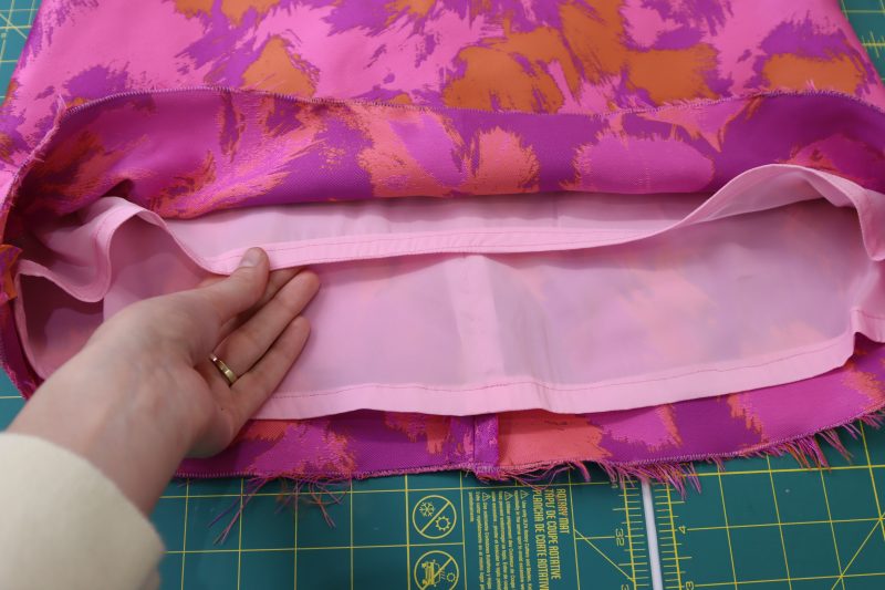 How To Sew Double Rolled Hem On Lining - Stretch Polyester Twill Lining - Mood Fabrics - Chelsea Brocade Set Free Sewing Pattern Tutorial - MDF508 - Mood Fabrics Sewciety Blog - Sew a double rolled hem on the bottom of the lining.