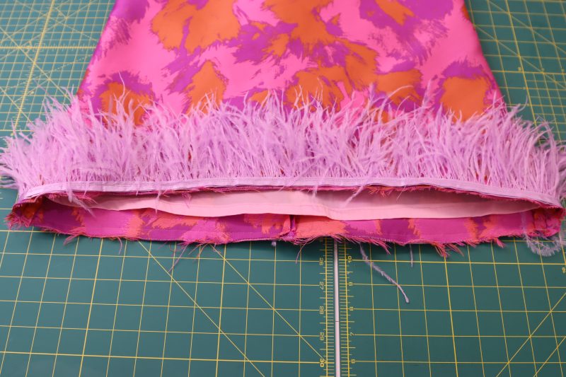How To Sew Trim To Top Hem - Ostrich Feather Trim - Mood Fabrics - Chelsea Brocade Set Free Sewing Pattern Tutorial - MDF508 - Mood Fabrics Sewciety Blog - Sew the trim to the bottom hem of the brocade.