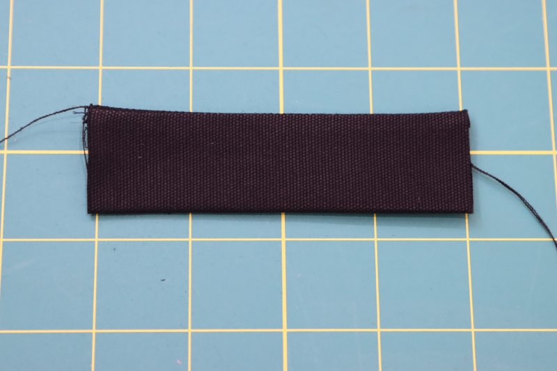 How To Flip Strap Right Sides Out - Cotton Canvas - Mood Fabrics - Colfax Carpenter Pants Free Sewing Pattern Tutorial - MDF504 - Mood Fabrics Sewciety Blog - Flip the strap right sides out with a loop turner.