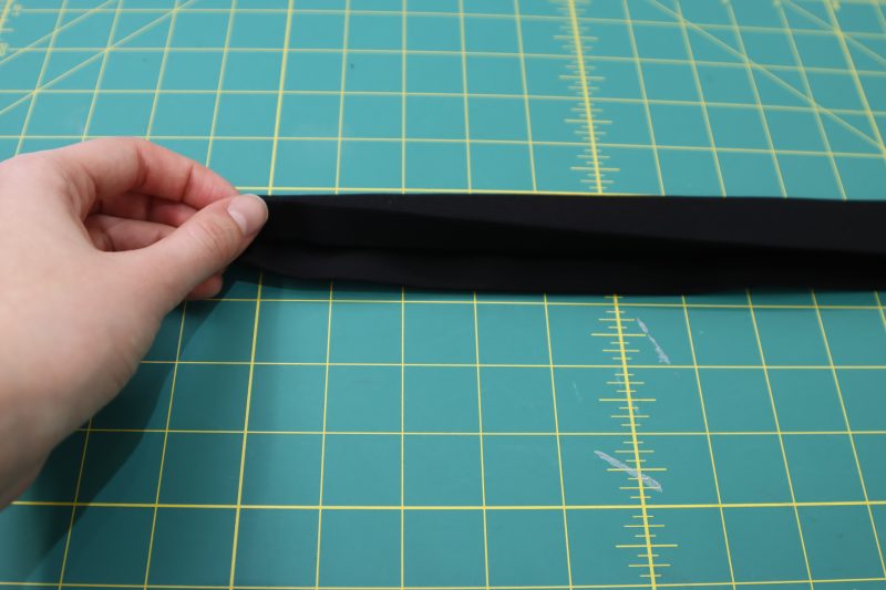 How To Fold Waistband Raw Edges - Cotton Canvas - Mood Fabrics - Colfax Carpenter Pants Free Sewing Pattern Tutorial - MDF504 - Mood Fabrics Sewciety Blog - Fold the raw edges of the waistband into the waistband and press into place.