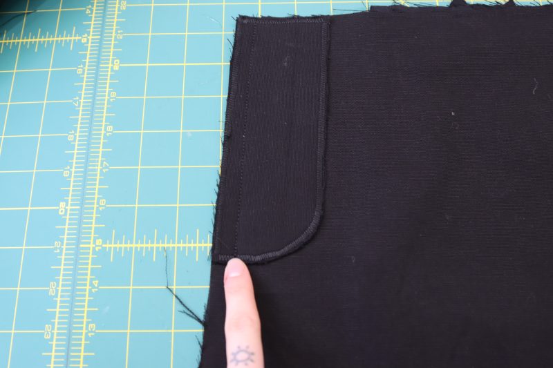 How To Pin Sew Fly Facing To Front Pants - Cotton Canvas - Mood Fabrics - Colfax Carpenter Pants Free Sewing Pattern Tutorial - MDF504 - Mood Fabrics Sewciety Blog - Pin and sew the fly facing to the front left pants piece at the center front.