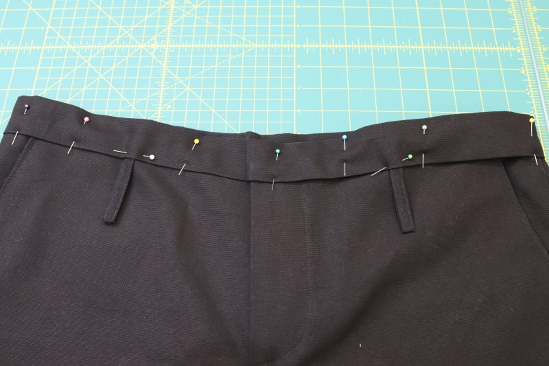 How To Sandwich Waistline Inside Wasitband - Cotton Canvas - Mood Fabrics - Colfax Carpenter Pants Free Sewing Pattern Tutorial - MDF504 - Mood Fabrics Sewciety Blog - Sandwich the waistline of the pants and the belt loops in between the two layers of the waistband.