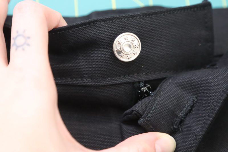 How To Insert Jeans Button Into Hole - Silver Jeans Button - Mood Fabrics - Colfax Carpenter Pants Free Sewing Pattern Tutorial - MDF504 - Mood Fabrics Sewciety Blog - Insert the jeans button into the hole.