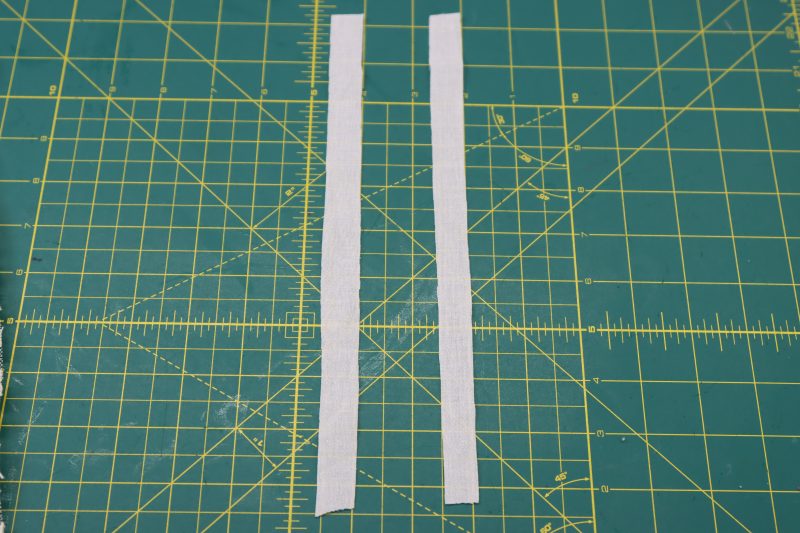 How To Cut Fusible Interfacing Strips - Fusible Interfacing - Mood Fabrics - Taiga Trapeze Skirt Free Sewing Pattern Tutorial - MDF512 - Mood Fabrics Sewciety Blog - Cut out two strips of interfacing that are 1 inch wide and roughly 10 inches long.