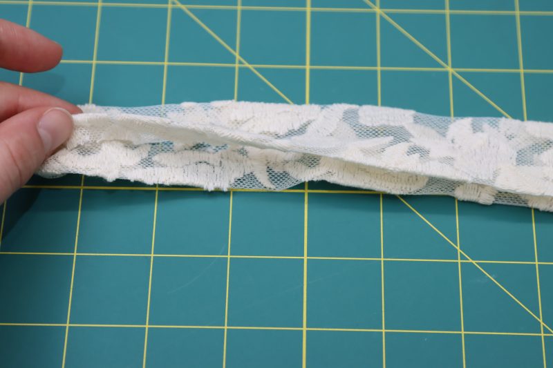 How To Fold Wasitband Raw Edges Inside - Embroidered Lace - Mood Fabrics - Taiga Trapeze Skirt Free Sewing Pattern Tutorial - MDF512 - Mood Fabrics Sewciety Blog - Fold the raw edges of the waistband into the inside of the waistband and press the fold.