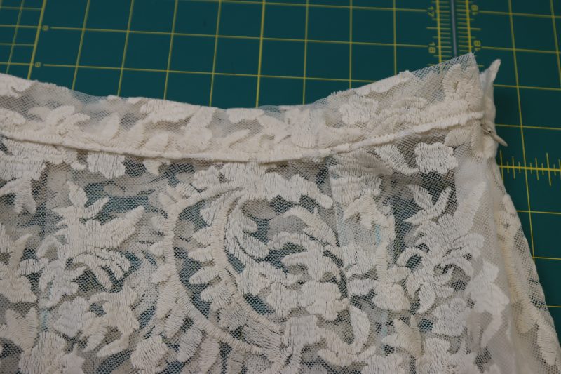 How To Topstitch Waistband To Skirt Waistline - Embroidered Lace - Mood Fabrics - Taiga Trapeze Skirt Free Sewing Pattern Tutorial - MDF512 - Mood Fabrics Sewciety Blog - Topstitch the bottom edge of the waistband to the skirt using ⅛ inch seam allowance.