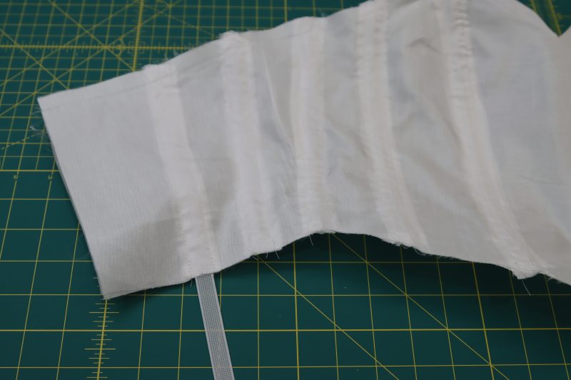 How To Insert Boning Into Prepared Bodice Channels - White Rigilene - Mood Fabrics - Selenite V Waist Ballgown Free Sewing Pattern Tutorial - MDF515 - Mood Fabrics Sewciety Blog - Insert boning into the channels between the lining bodice and the interfacing bodice.