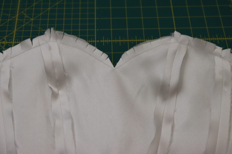 How To Clip Neckline Seam Allowance Before Turning Out - Polyester Mikado - Mood Fabrics - Selenite V Waist Ballgown Free Sewing Pattern Tutorial - MDF515 - Mood Fabrics Sewciety Blog - Clip the neckline before flipping the bodice right sides out.