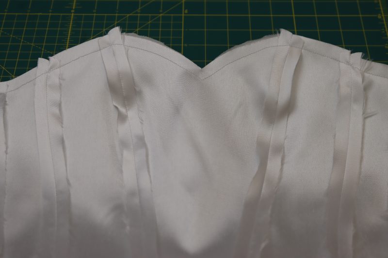 How To Pin Sew Shell And Lining Necklines Together - Polyester Mikado - Mood Fabrics - Selenite V Waist Ballgown Free Sewing Pattern Tutorial - MDF515 - Mood Fabrics Sewciety Blog - Pin and sew the necklines of the shell and lining bodice right sides together.