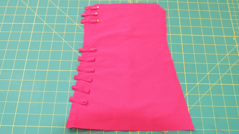 How To Pin Button Loops To Cuff - Polyester Taffeta - Mood Fabrics - Biella Fit and Flare Dress Free Sewing Pattern Tutorial - MDF514 - Mood Fabrics Sewciety Blog - Pin the button loops to the cuff, skipping the gap for the thumb hole.