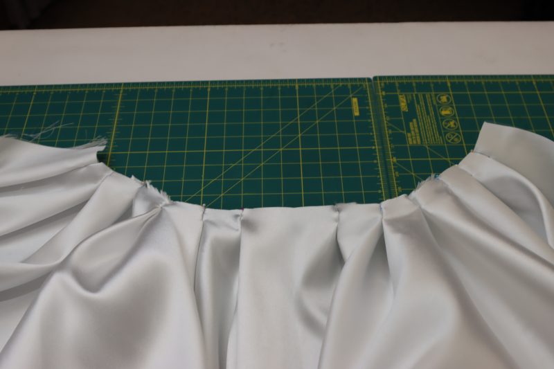 How To Pin Pleats At Calculated Depth And Position - Polyester Mikado - Mood Fabrics - Selenite V Waist Ballgown Free Sewing Pattern Tutorial - MDF515 - Mood Fabrics Sewciety Blog - Pin your pleats to the calculated depth with the chalk mark at the fold of each pleat.