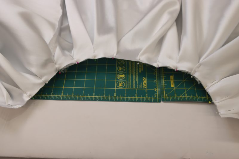 How To Press Box Pleats Into Place - Polyester Mikado - Mood Fabrics - Selenite V Waist Ballgown Free Sewing Pattern Tutorial - MDF515 - Mood Fabrics Sewciety Blog - Press and pin the box pleats into place.