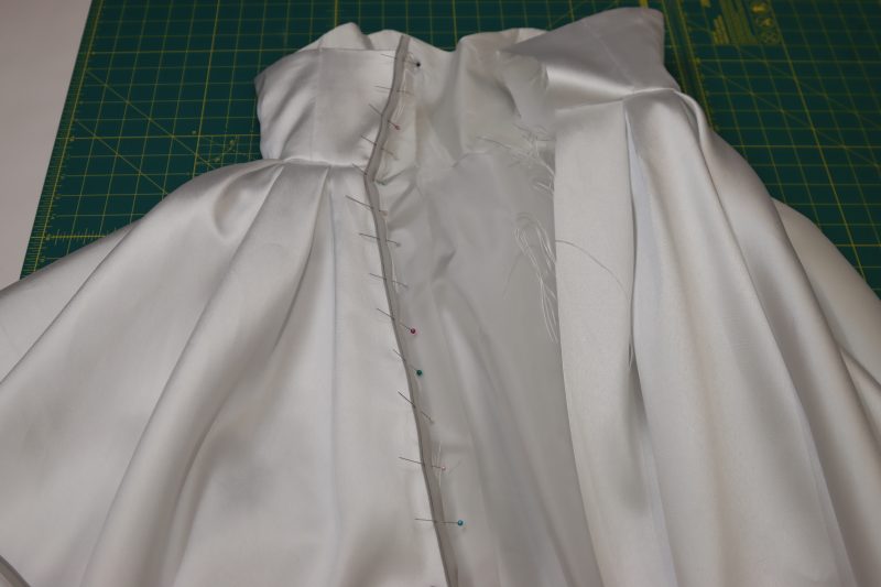 How To Pin Zipper To Left Side Of Center Back - Invisible Zipper - Mood Fabrics - Selenite V Waist Ballgown Free Sewing Pattern Tutorial - MDF515 - Mood Fabrics Sewciety Blog - Pin the zipper right sides together with the wearer’s left side of the center back of the dress.