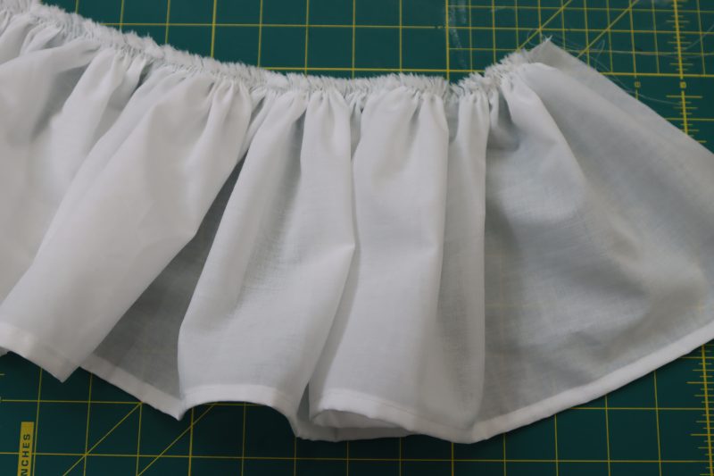 How To Pull Threads To Gather Ruffle Top Edge - Cotton Voile - Mood Fabrics - Selenite V Waist Ballgown Free Sewing Pattern Tutorial - MDF515 - Mood Fabrics Sewciety Blog - Gather the top edge of the ruffles.