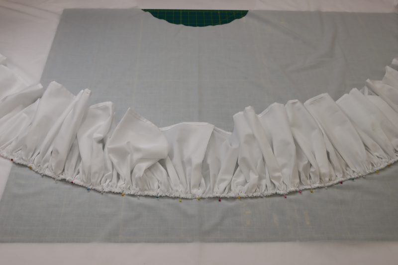 How To Pin Bottom Ruffle Around Skirt Perimeter - Cotton Voile - Mood Fabrics - Selenite V Waist Ballgown Free Sewing Pattern Tutorial - MDF515 - Mood Fabrics Sewciety Blog - Pin the bottom ruffle around the perimeter of the skirt.