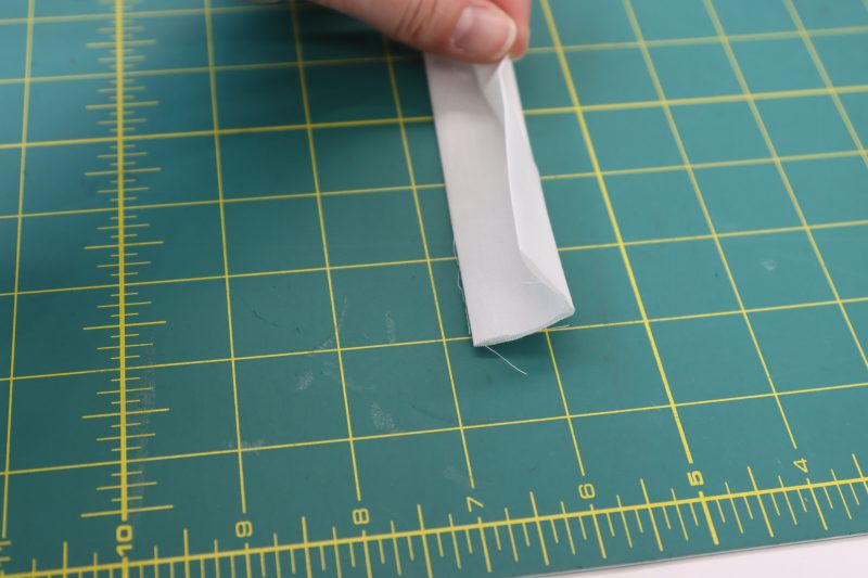 How To Fold Waistband In Half To Enclose Edges - Cotton Voile - Mood Fabrics - Selenite V Waist Ballgown Free Sewing Pattern Tutorial - MDF515 - Mood Fabrics Sewciety Blog - Fold the strip in half longways once more.