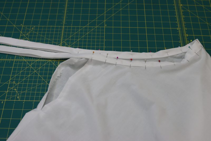 How To Pin Waistband Around Petticoat Waistline Evenly - Cotton Voile - Mood Fabrics - Selenite V Waist Ballgown Free Sewing Pattern Tutorial - MDF515 - Mood Fabrics Sewciety Blog - Pin the waistline of the skirt into the waistband.