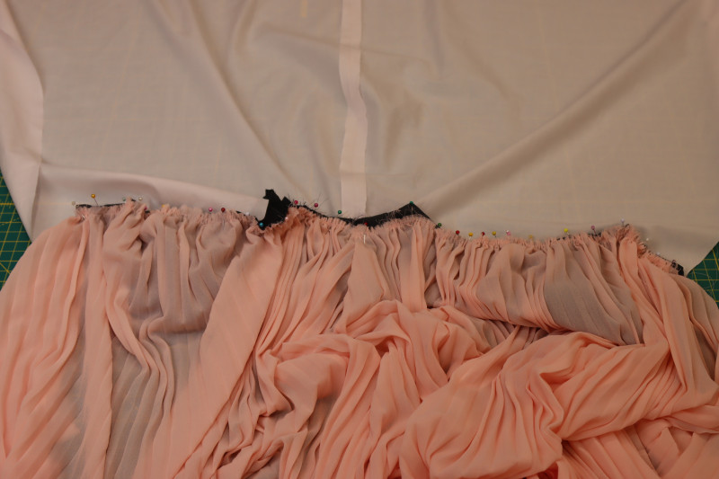 How To Pin Gathered Waistline Of Pleated Skirt To Outer Layer Of Bodice - Accordion Pleated Chiffon - Mood Fabrics - Pyrite Pleated Dress Free Sewing Pattern Tutorial - MDF527 - Mood Fabrics Sewciety Blog - Pin the gathered waistline of the pleated skirt to the outer layer of the bodice.