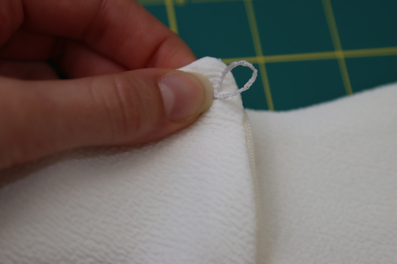 How To Sew Chain Stitched Loop Of Thread Opposite To The Button - Gutermann Sew All Thread - Mood Fabrics - Merano Balloon Sleeve Blouse Free Sewing Pattern Tutorial - MDF522 - Mood Fabrics Sewciety Blog - Sew a chain stitched loop of thread opposite to the button.