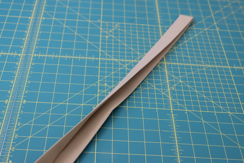 How To Fold Raw Edges Of Waistband Towards Inside Of Waistband And Press - Stretch Khaki Twill - Mood Fabrics - Lucca Tailored Barrel Leg Pants Free Sewing Pattern Tutorial - MDF524 - Mood Fabrics Sewciety Blog - Fold the raw edges of the waistband towards the inside of the waistband and press.