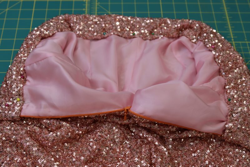 How To Pin Folded Inner Edge Of The Waistband To The Lining - Baby Sequin Mesh - Mood Fabrics - Morganite Waistcoat Ensemble Free Sewing Pattern Tutorial - MDF519 - Mood Fabrics Sewciety Blog - Pin the folded inner edge of the waistband to the lining.