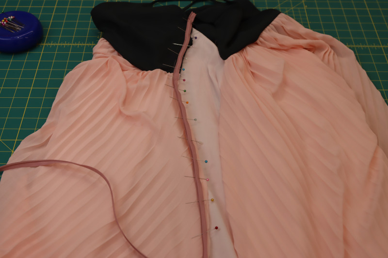 How To Pin Zipper With Main Fabric Of Skirt - Polester Chiffon - Mood Fabrics - Pyrite Pleated Dress Free Sewing Pattern Tutorial - MDF527 - Mood Fabrics Sewciety Blog - Pin the zipper right sides together with the main fabric of the skirt.