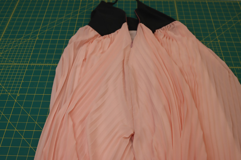 How To Sew Other Side Of Zipper Between Main Skirt And Lining Skirt - Invisible Zipper - Mood Fabrics - Pyrite Pleated Dress Free Sewing Pattern Tutorial - MDF527 - Mood Fabrics Sewciety Blog - Sew the other side of the zipper between the main skirt and the lining skirt.