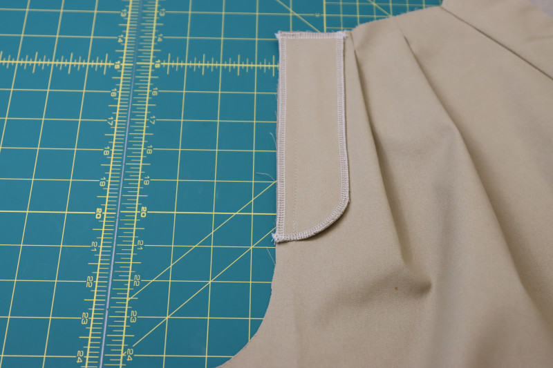 How To Pin Sew Fly Facing To Front Left Crotch Seam - Stretch Khaki Twill - Mood Fabrics - Lucca Tailored Barrel Leg Pants Free Sewing Pattern Tutorial - MDF524 - Mood Fabrics Sewciety Blog - Pin and sew the fly facing to the front left crotch seam.