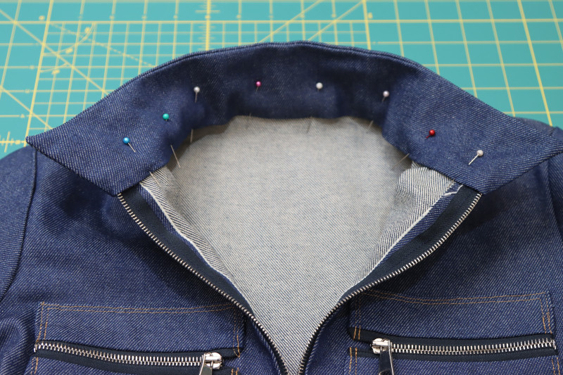 How To Pin Collar Folded Edge Pinned To Seam - Cotton Denim Twill - Mood Fabrics - Merit Jumpsuit Free Sewing Pattern Tutorial - MDF525 - Mood Fabrics Sewciety Blog - Pin the folded edge of the collar to the neckline seam.