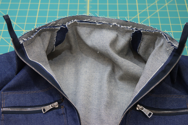 How To Sew Collar Attached To Neckline Second Layer - Cotton Denim Twill - Mood Fabrics - Merit Jumpsuit Free Sewing Pattern Tutorial - MDF525 - Mood Fabrics Sewciety Blog - Sew one of the layers of the collar to the neckline of the jumpsuit.