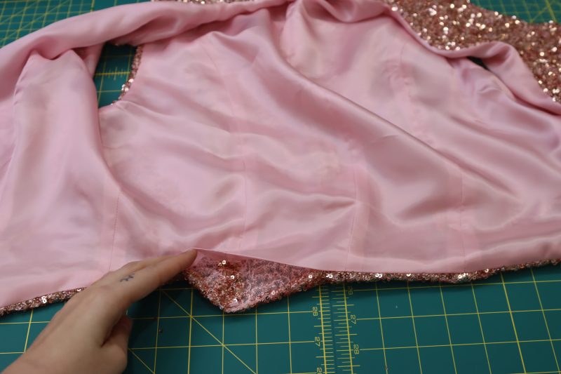 How To Press Raw Edges Of The Hem Opening - Baby Sequin Mesh - Mood Fabrics - Morganite Waistcoat Ensemble Free Sewing Pattern Tutorial - MDF519 - Mood Fabrics Sewciety Blog - Press the raw edges of the hem opening.