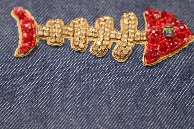How To Sew Applique Hand Sewn Whip Stitch - Skeletal Fish Applique - Mood Fabrics - Merit Jumpsuit Free Sewing Pattern Tutorial - MDF525 - Mood Fabrics Sewciety Blog - Hand sew the edges/backing of the applique to the jumpsuit with a whip stitch.