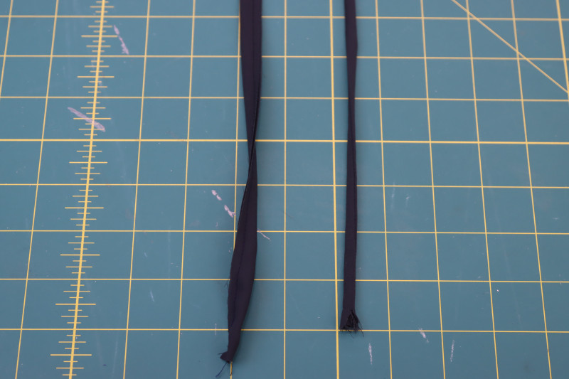 How To Flip Strap Right Sides Out With Tube Turner - Double Polyester Georgette - Mood Fabrics - Pyrite Pleated Dress Free Sewing Pattern Tutorial - MDF527 - Mood Fabrics Sewciety Blog - Flip the strap right sides out with a tube turner.